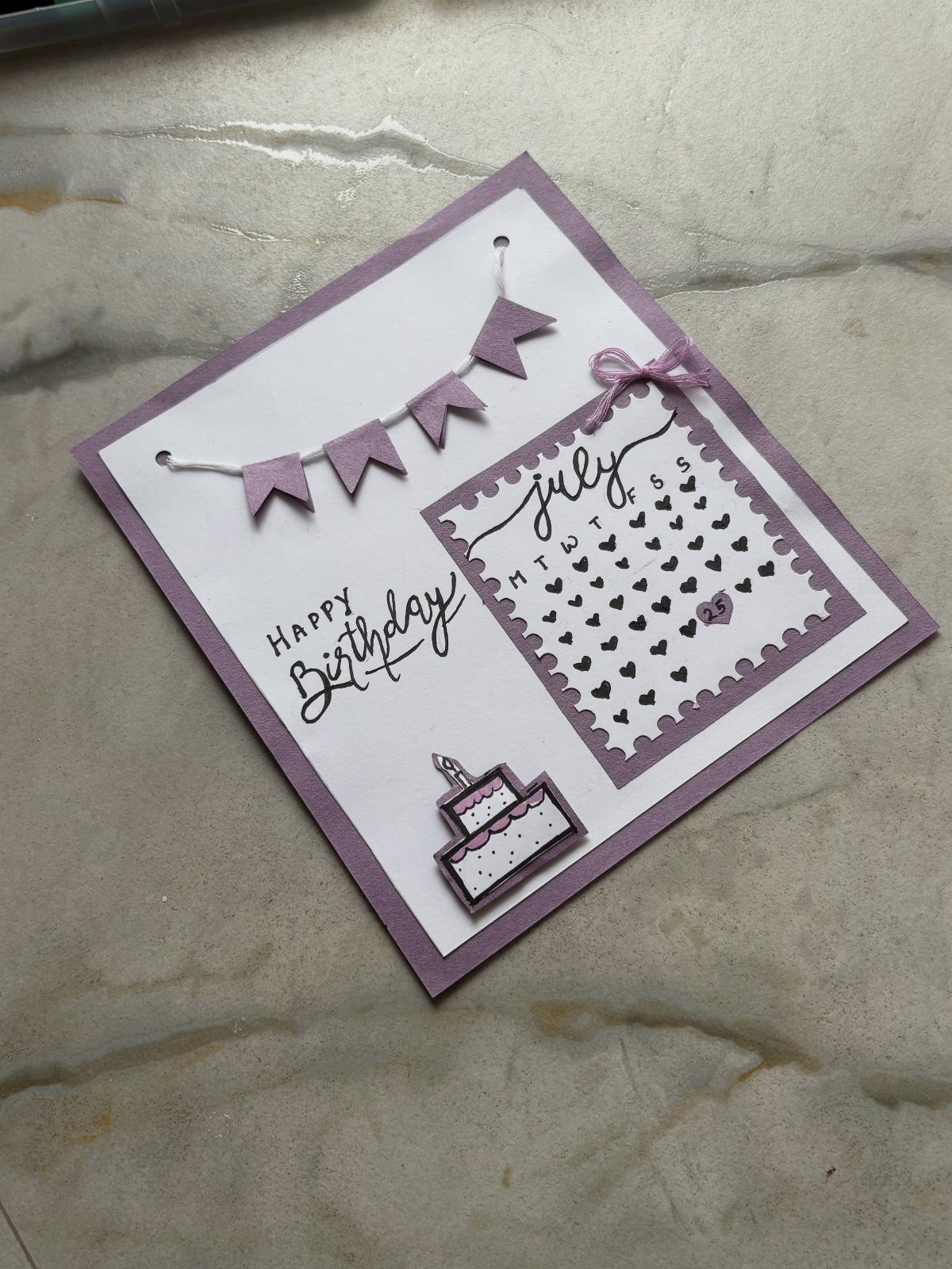 Handmade purple birthday card with a small bunting banner and July calendar.