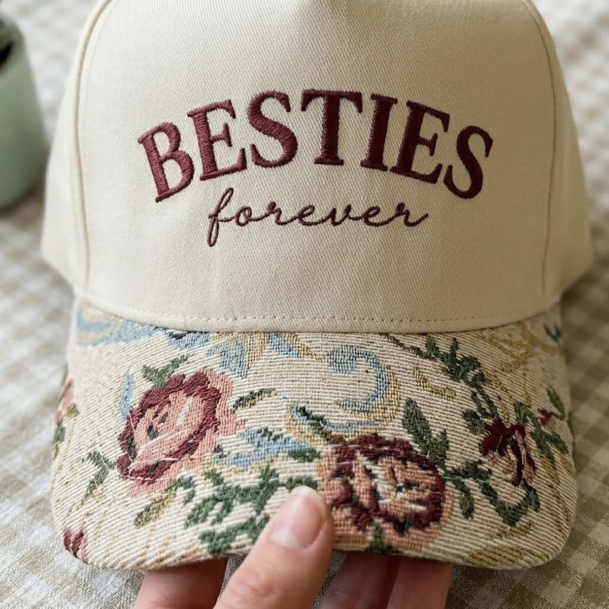 Cream baseball cap with burgundy BESTIES forever embroidery and floral tapestry brim.