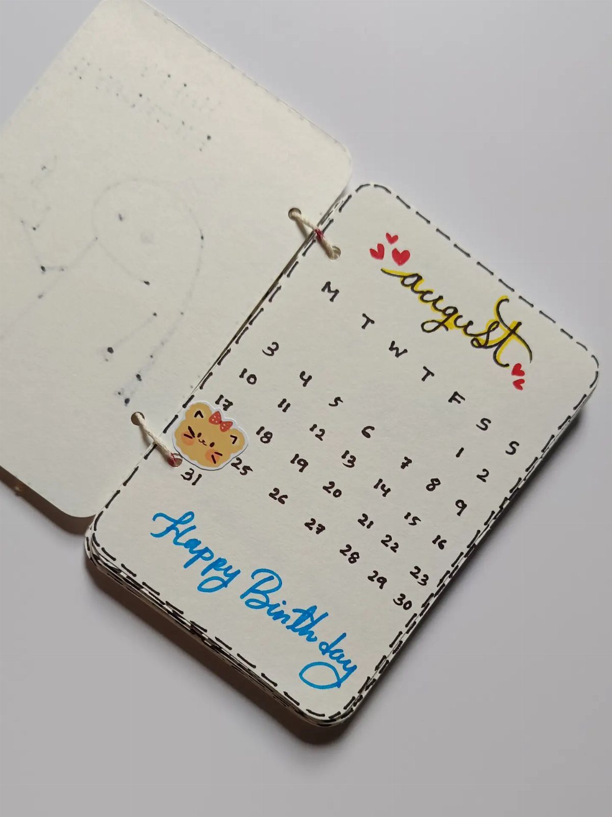 Handmade August birthday calendar with a cute cat illustration and blue cursive text.