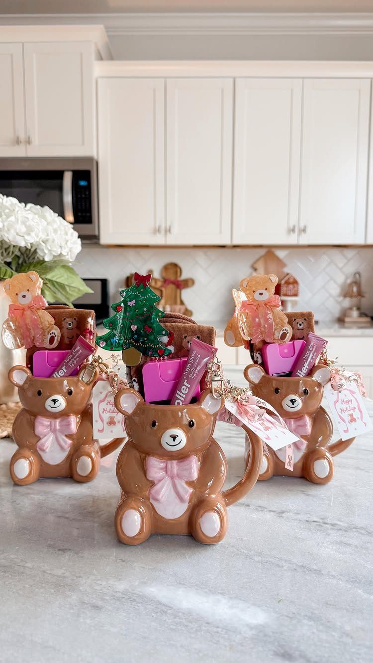 Bear-shaped ceramic mugs filled with small gifts and treats on a marble counter