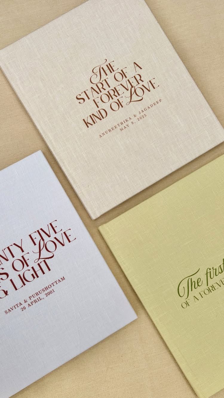 Three linen photo albums with romantic cursive text on the covers.