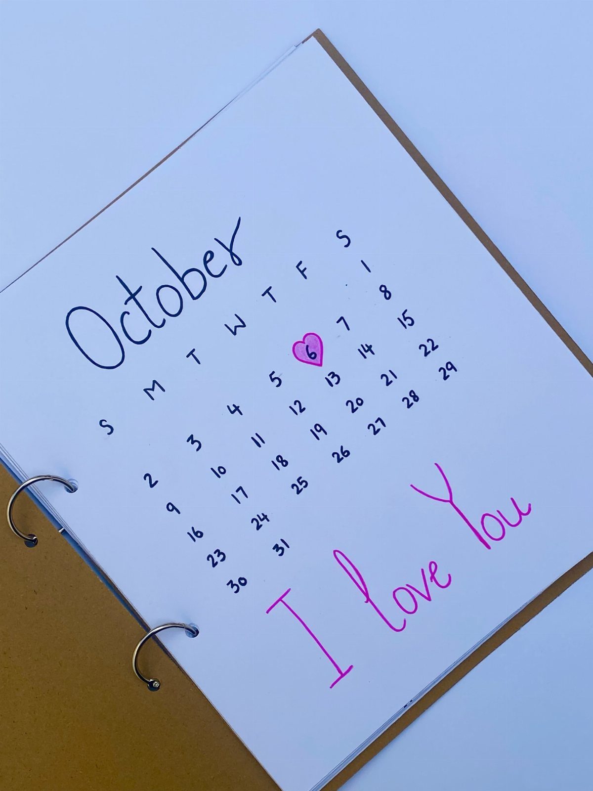Handmade October calendar with a pink heart circling a date and love note.