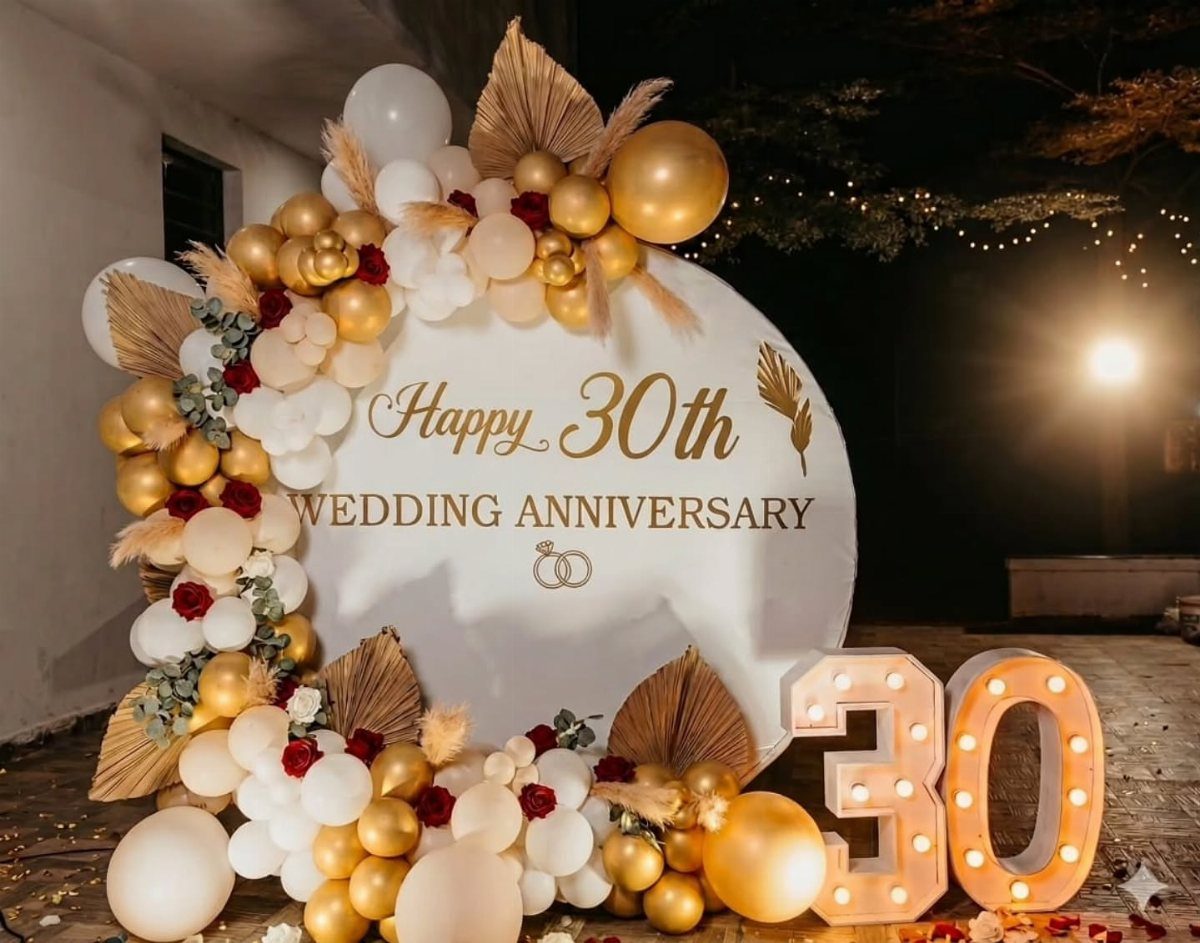 Large illuminated marquee numbers 30 next to a white anniversary backdrop with balloons.