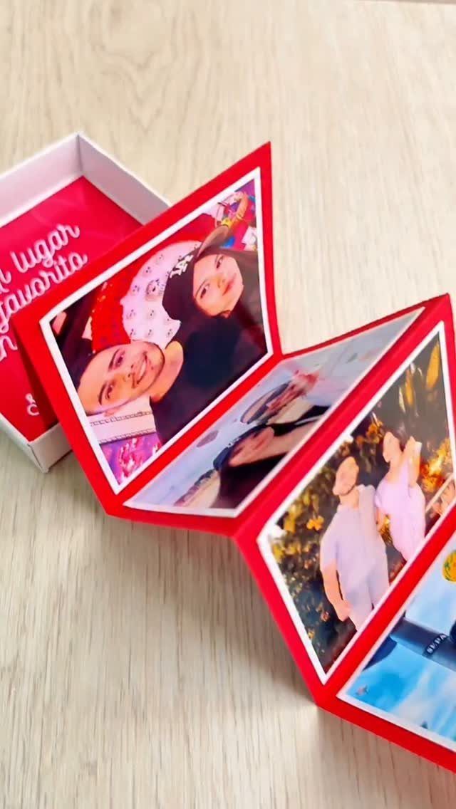 Red pop-up photo box unfolding to reveal pictures of a couple on wood.