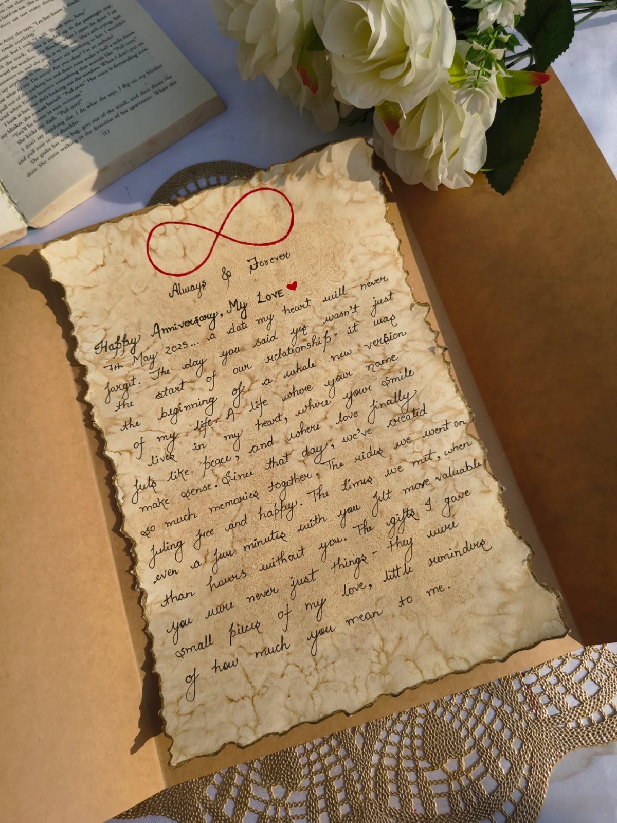 Handwritten love letter on aged parchment paper with a red infinity symbol and roses.