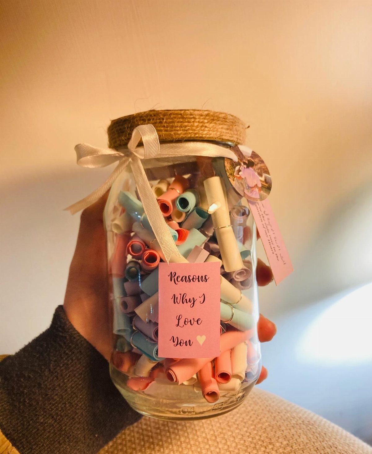 Glass jar filled with colorful rolled paper notes and a love label.