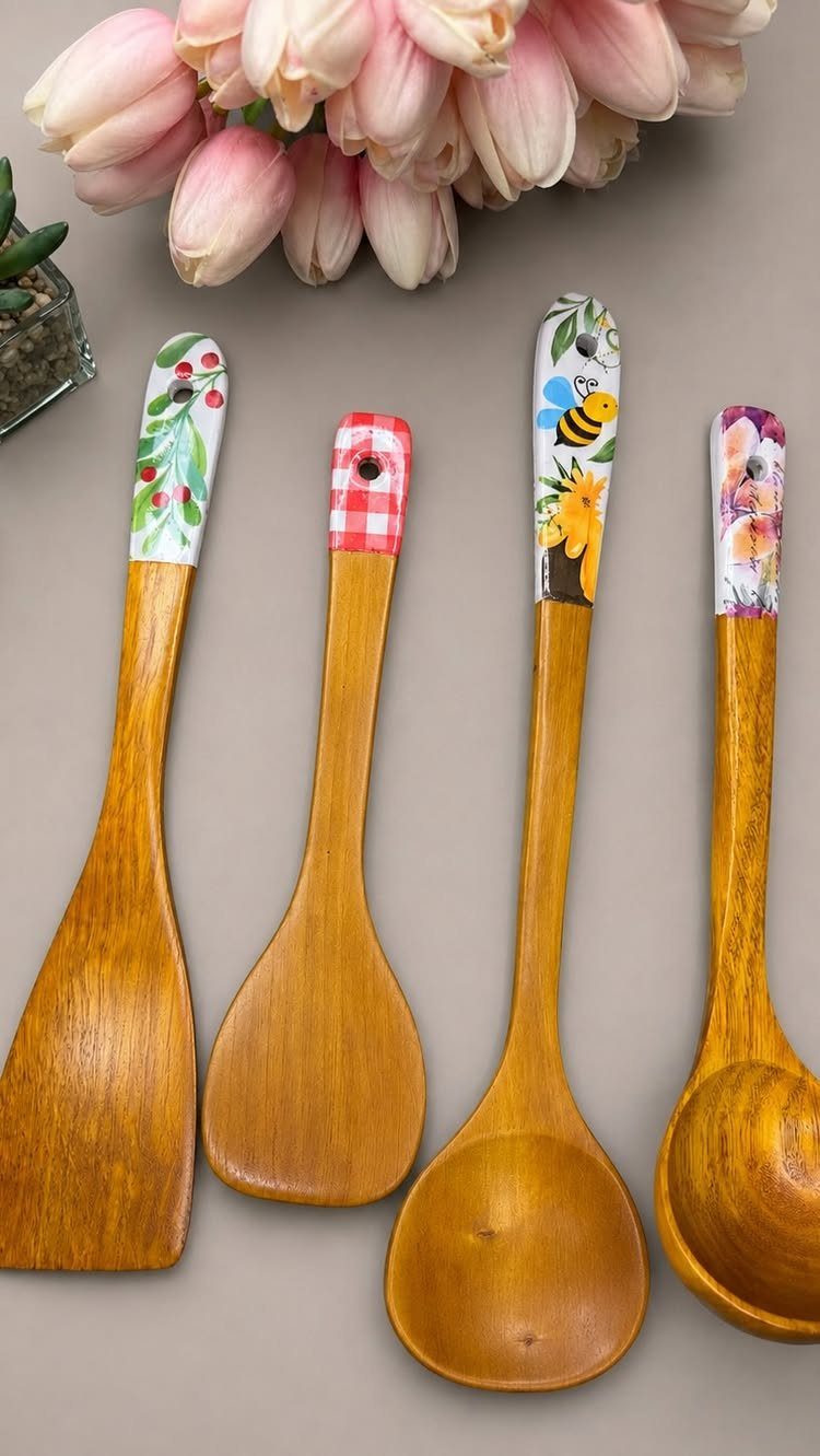 Wooden kitchen spoons with decorative floral and checkered decoupage patterns on the handles.