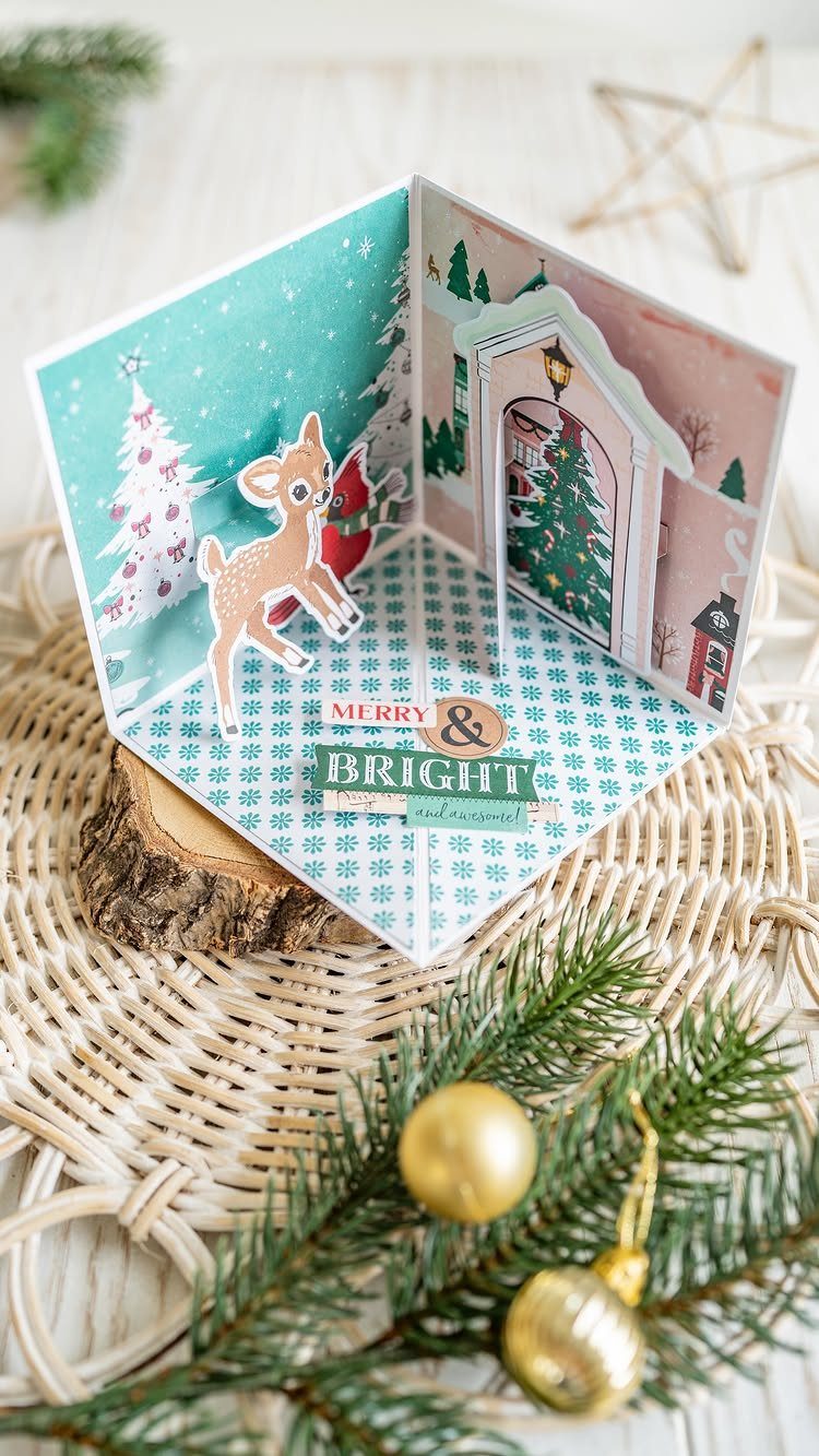 Pop-up Christmas card with a reindeer and tree on a rustic wooden surface.