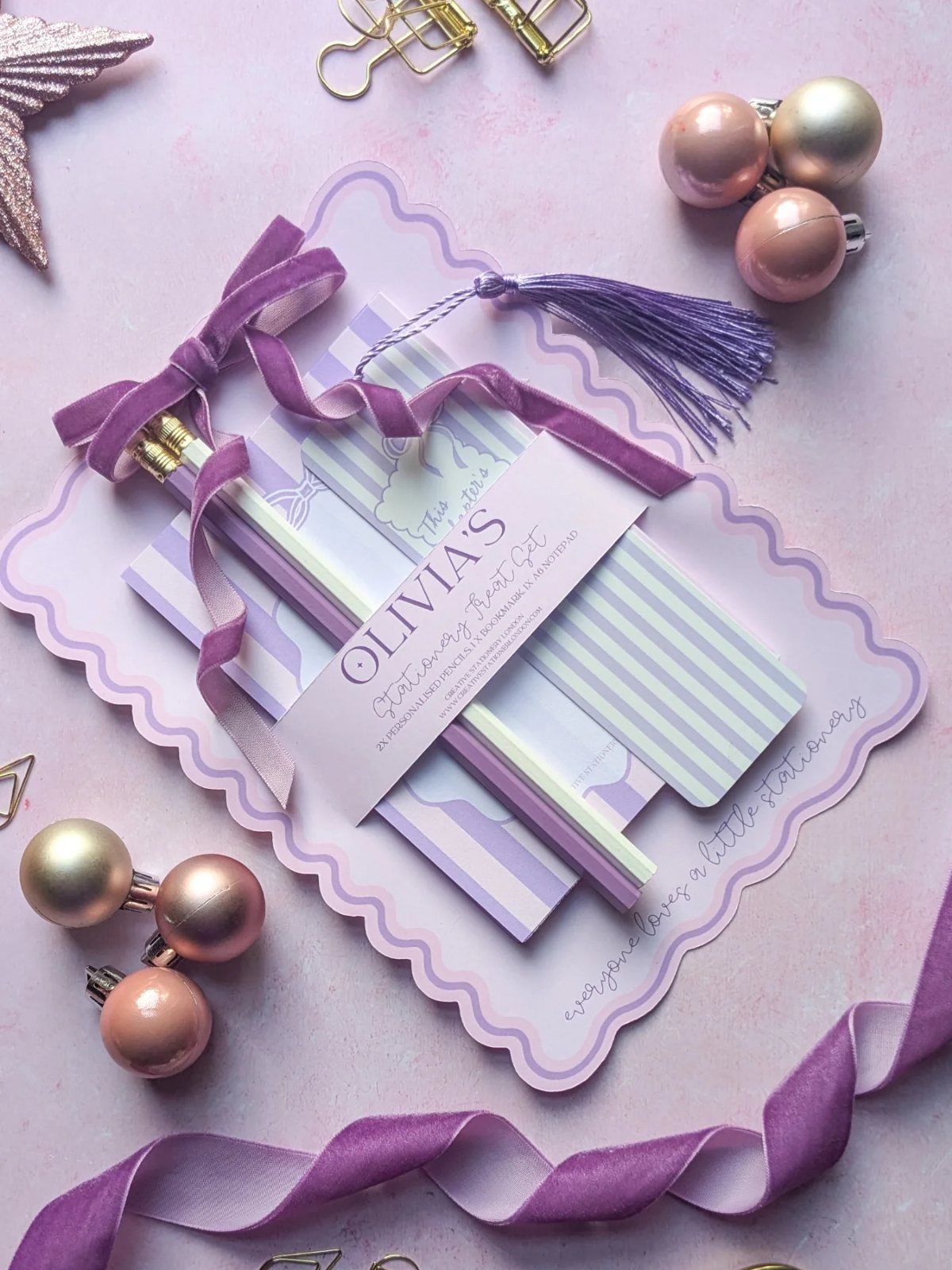 Personalized stationery set with purple striped notecards, pencils, and a name tag.