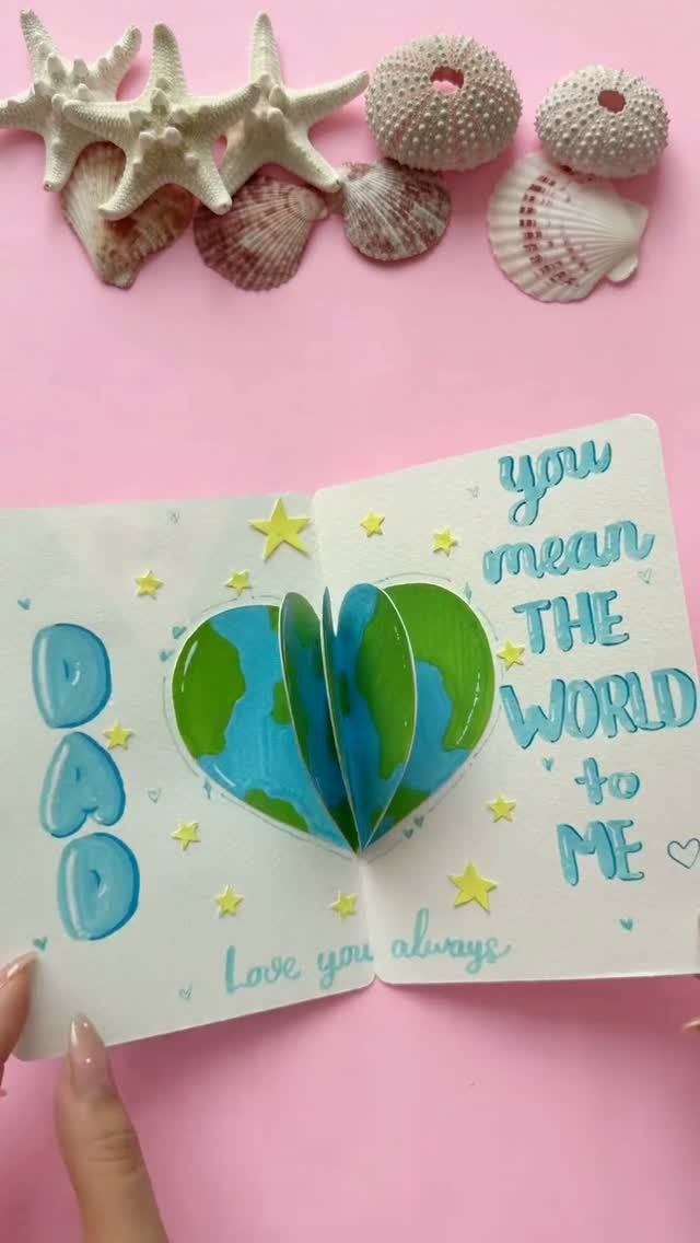 Handmade pop-up Father's Day card with a 3D heart-shaped globe and seashells.