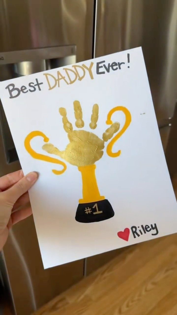 Gold paint handprint trophy on white paper with Best Daddy Ever text.