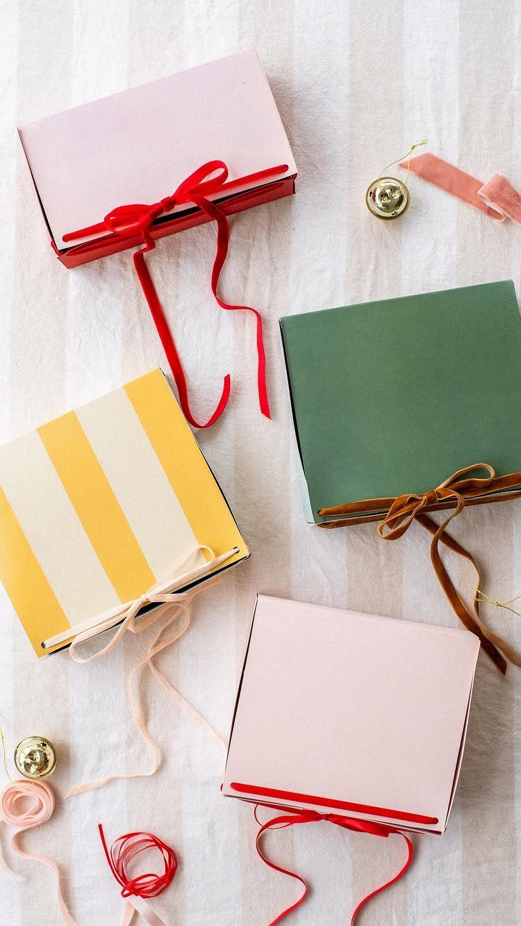 Handmade gift boxes in pink, green, and yellow stripes tied with colorful ribbons.
