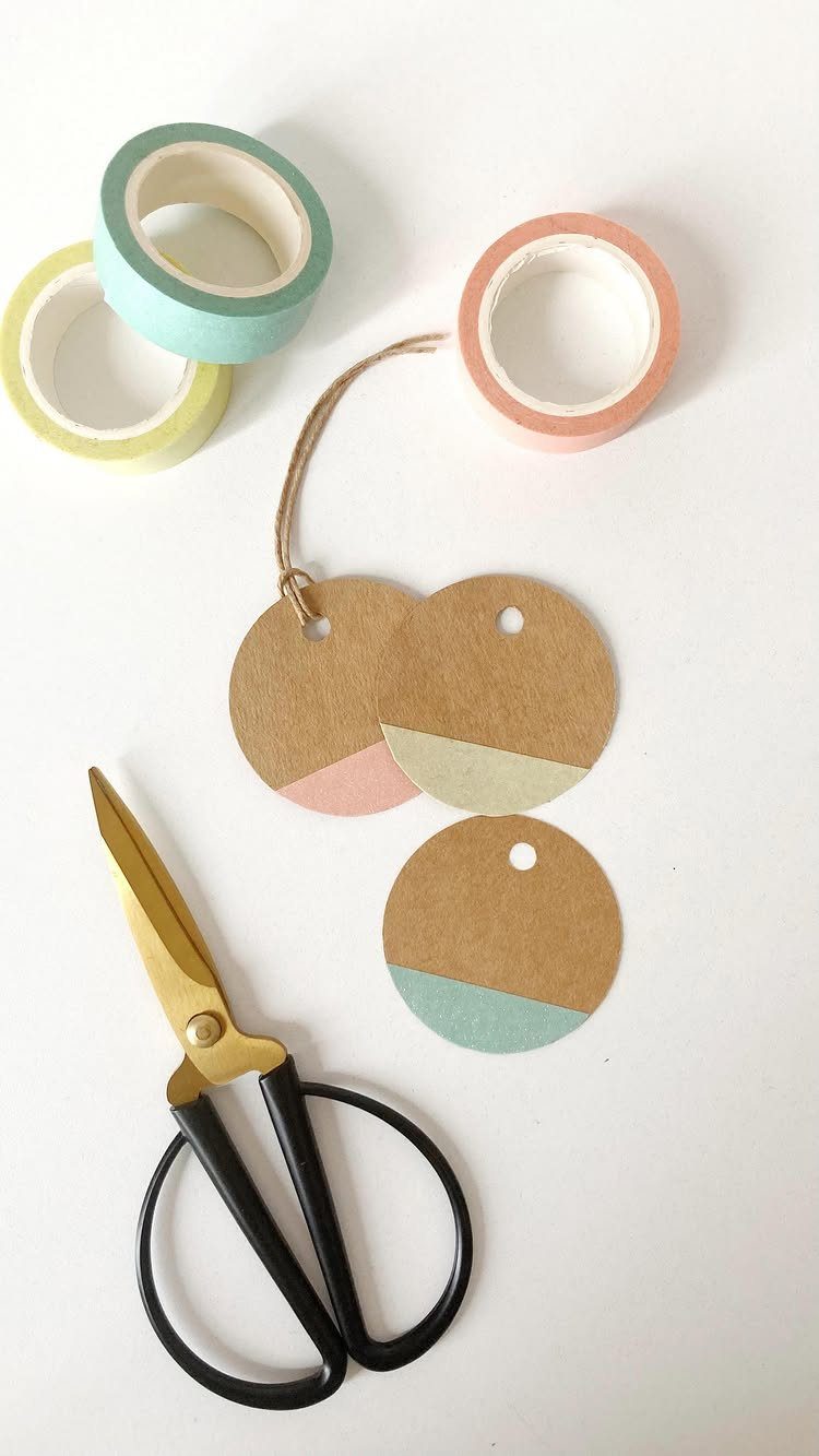 Circular brown cardboard gift tags decorated with colorful washi tape and craft supplies.