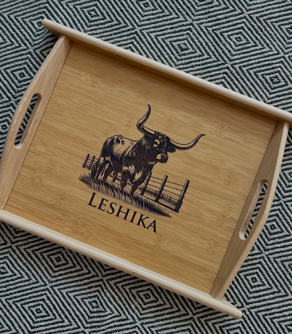Wooden serving tray with an engraved bull and the name Leshika on it.