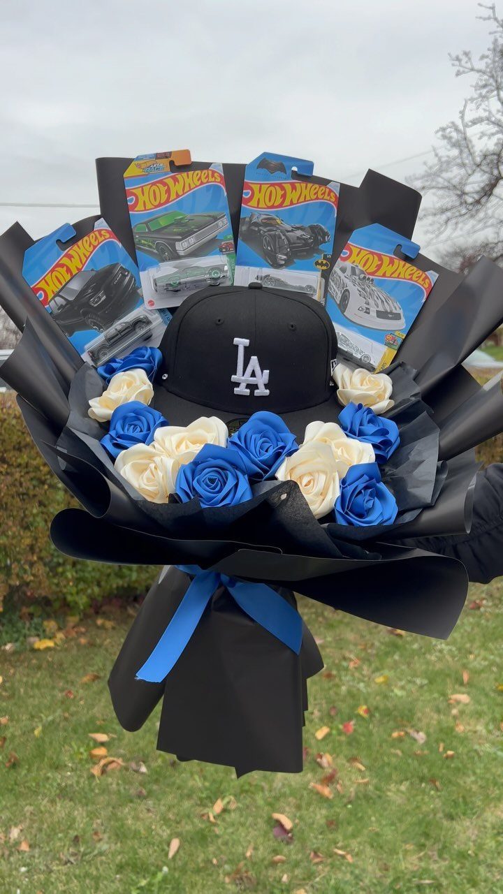 Gift bouquet with LA Dodgers cap, Hot Wheels cars, and blue and white roses.