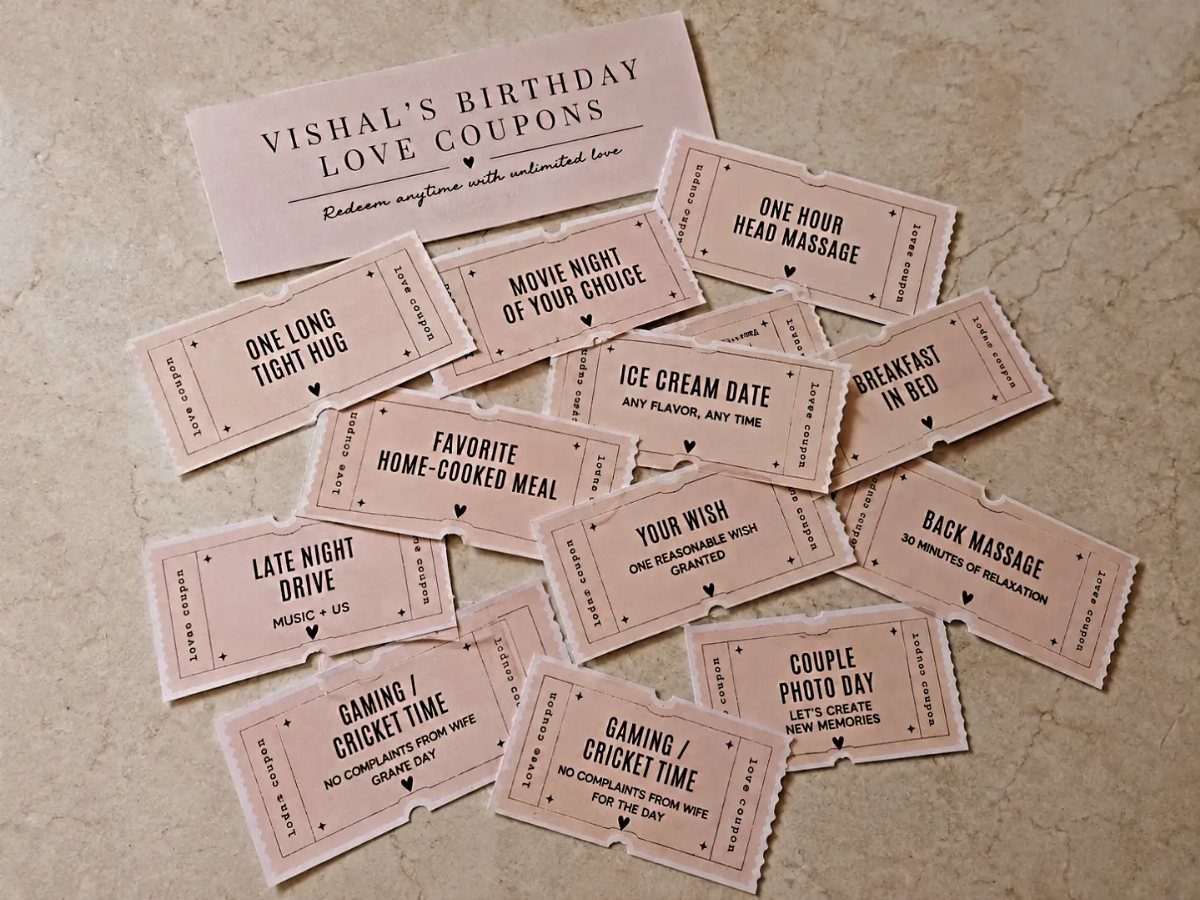 Pink handmade love coupons for a birthday scattered on a beige stone surface.