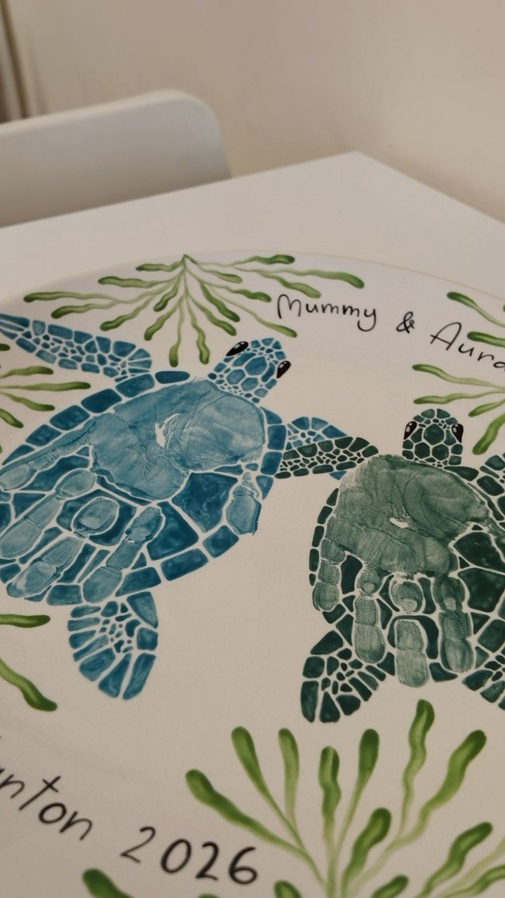 White ceramic plate with painted blue and green sea turtles and handwritten text.