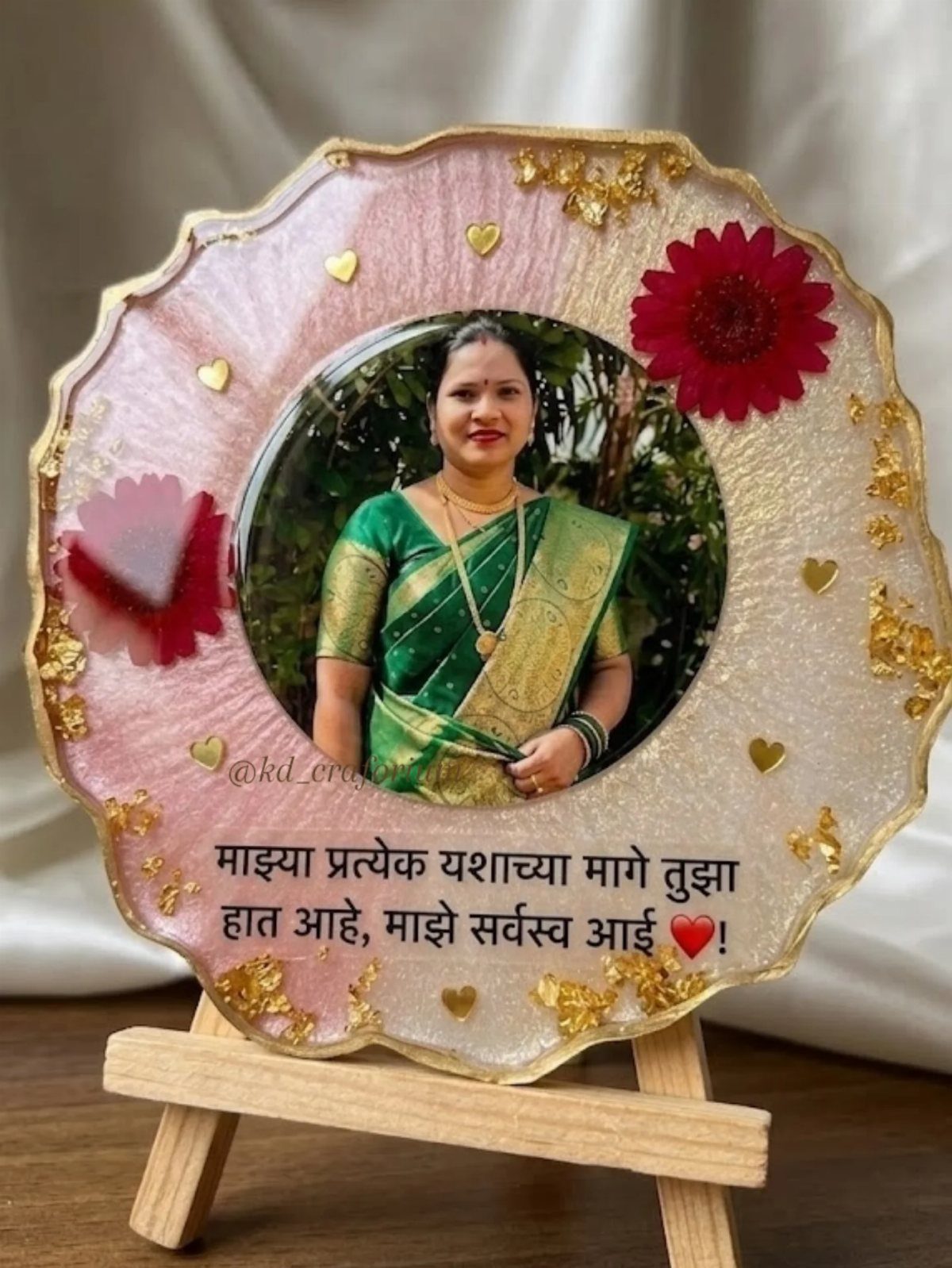 Resin art plaque with a woman's photo, gold foil, and red flowers on easel
