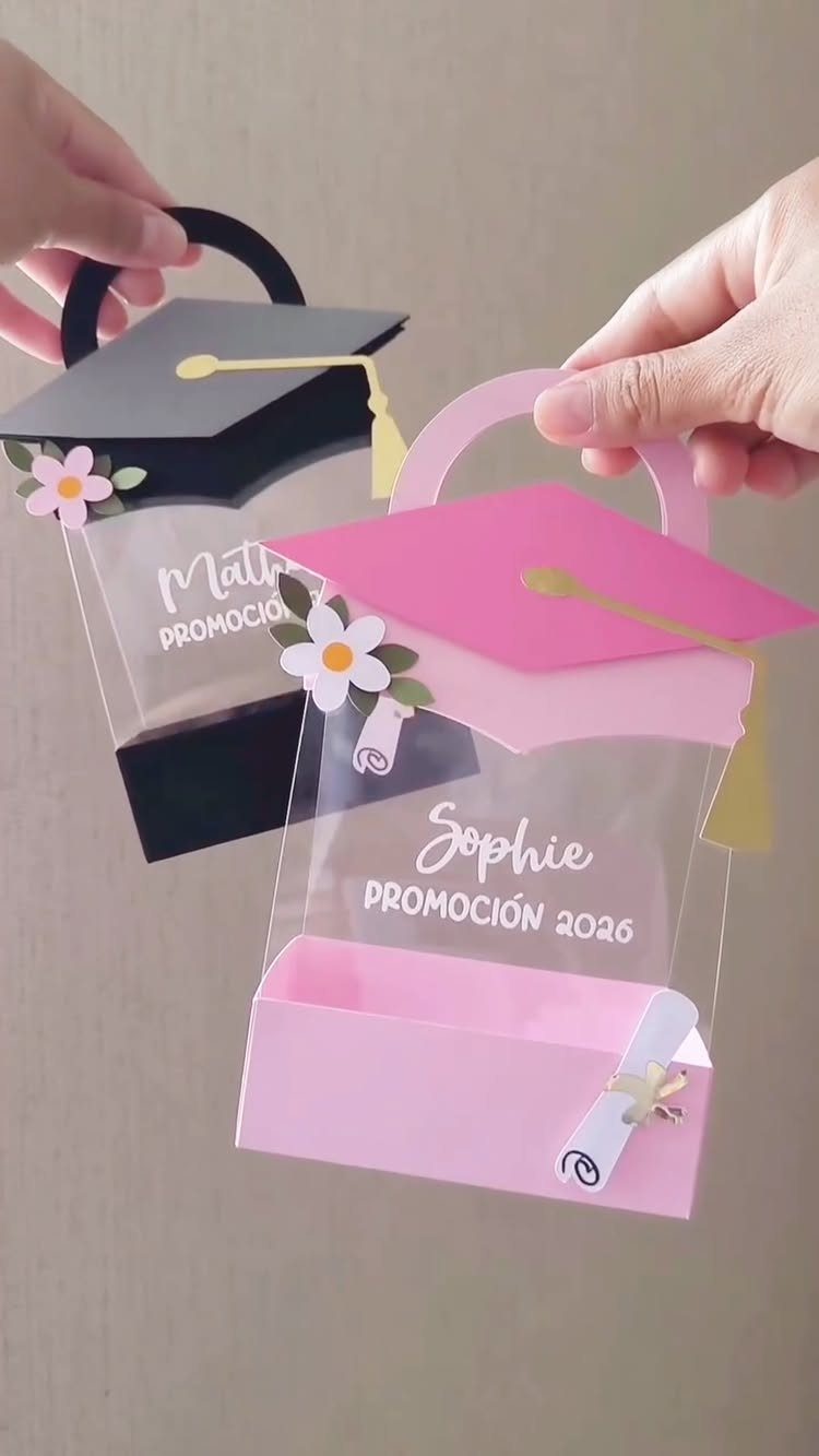 Graduation cap shaped gift bags in black and pink with personalized names.