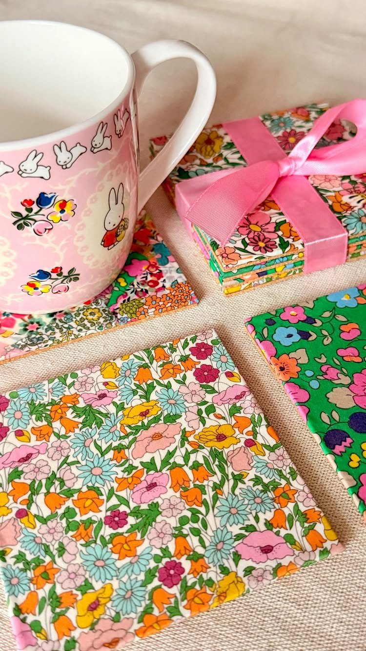 Floral fabric coasters with a pink bunny mug and a ribbon-tied stack.