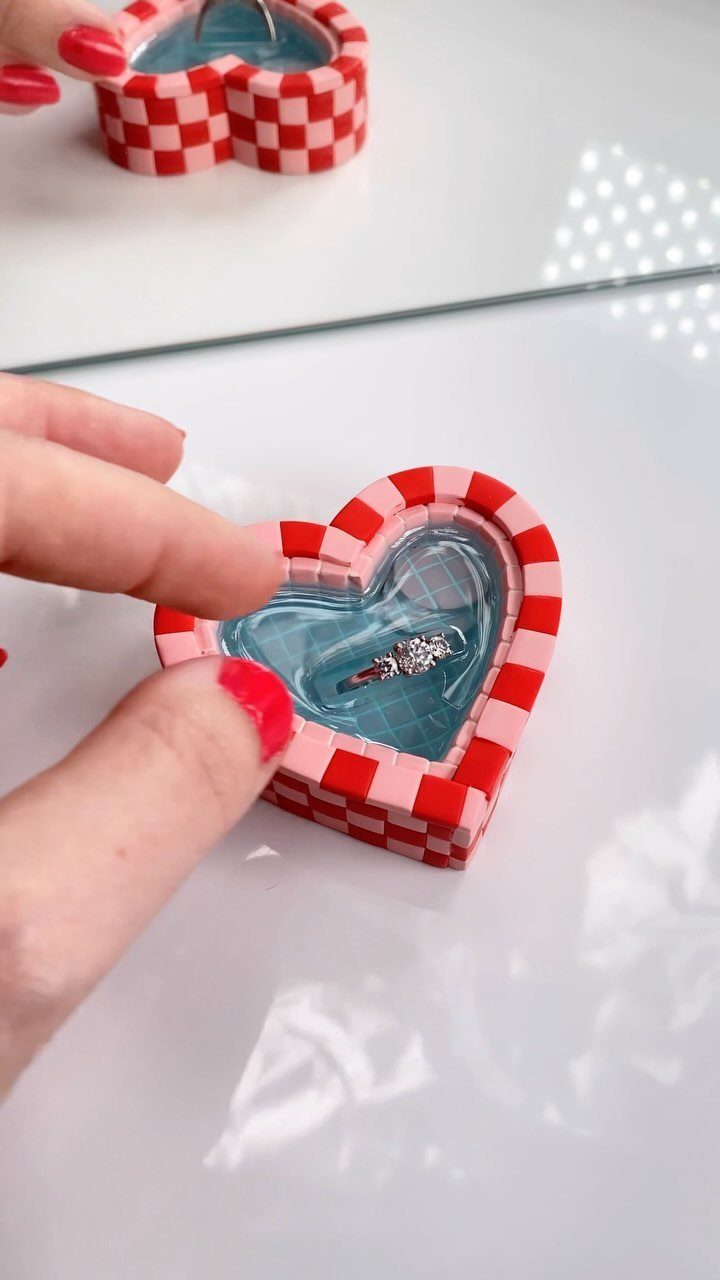 Heart-shaped clay ring dish with red checkered rim and blue resin center.