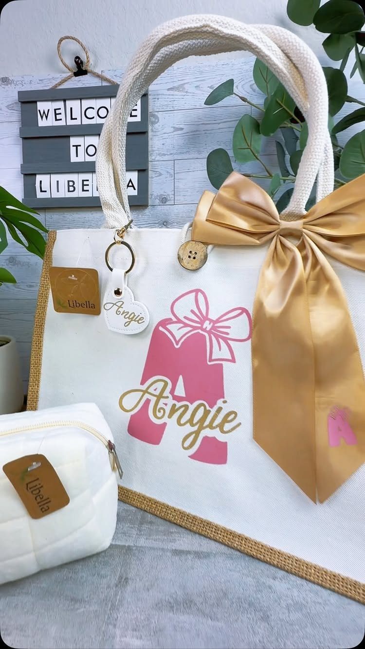 White canvas market tote bag personalized with the name Angie and a gold bow.
