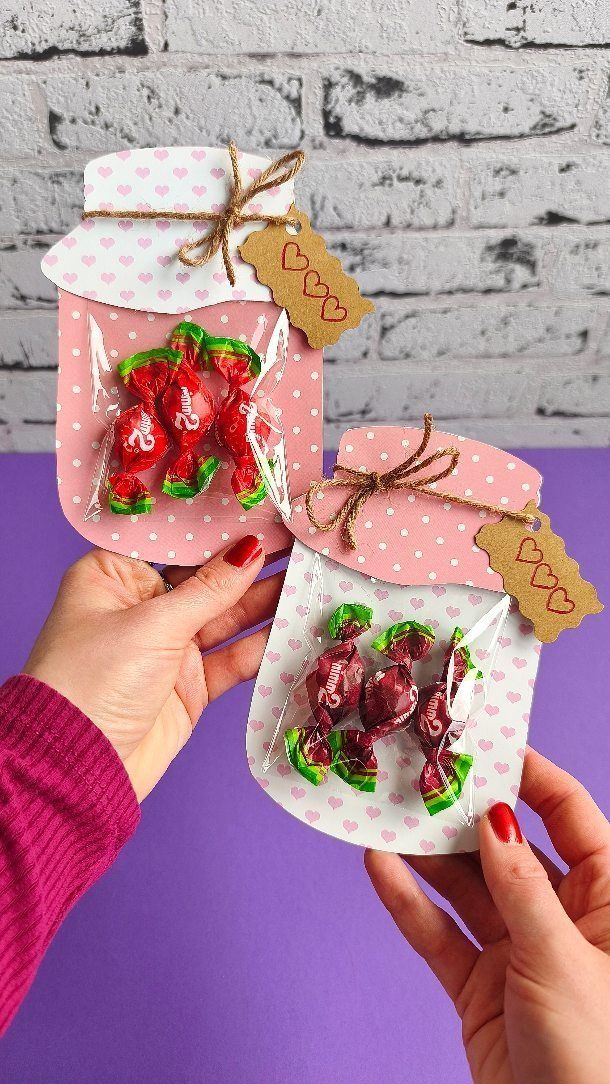 Paper jar cutouts filled with wrapped candies and tied with twine bows.