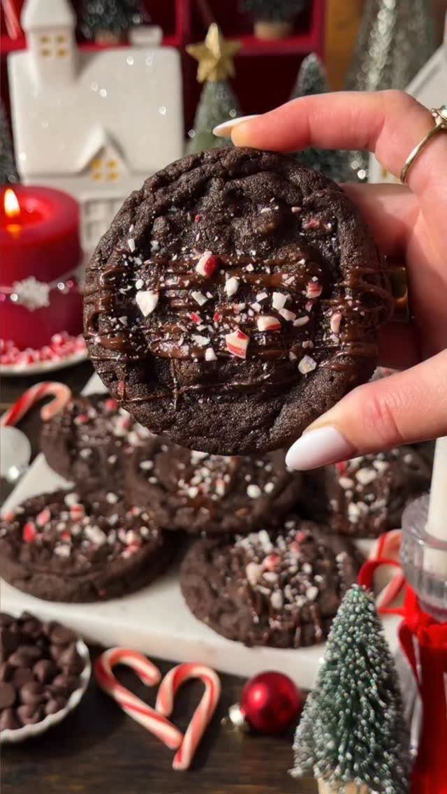 Chocolate peppermint cookies with crushed candy on top held by a hand.