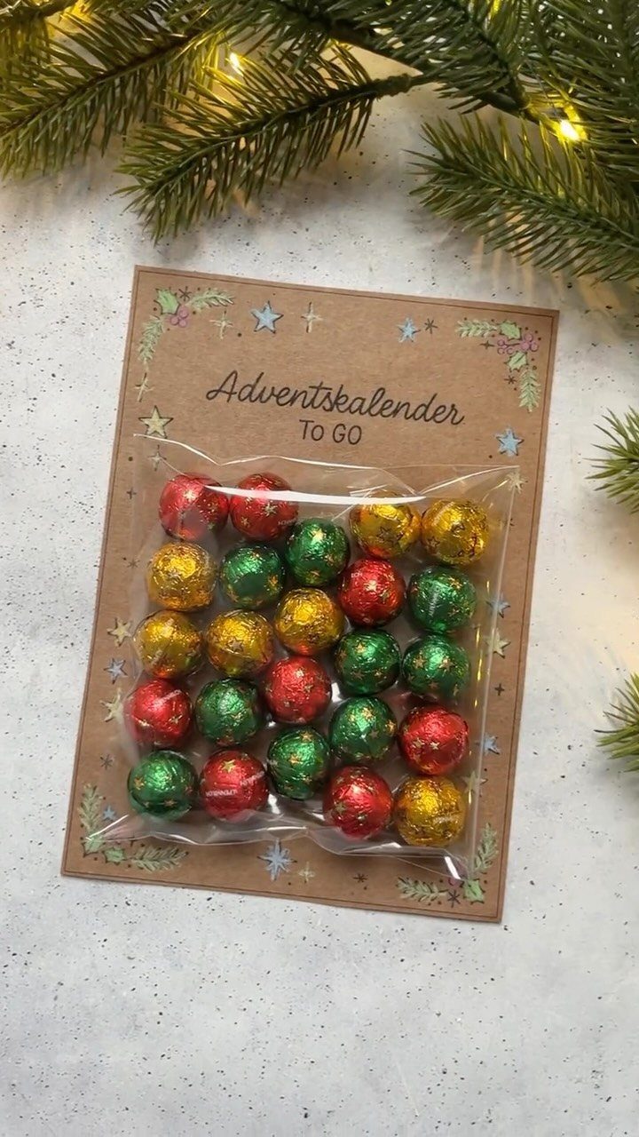 Handmade advent calendar with foil-wrapped chocolates in a bag on cardboard backing.