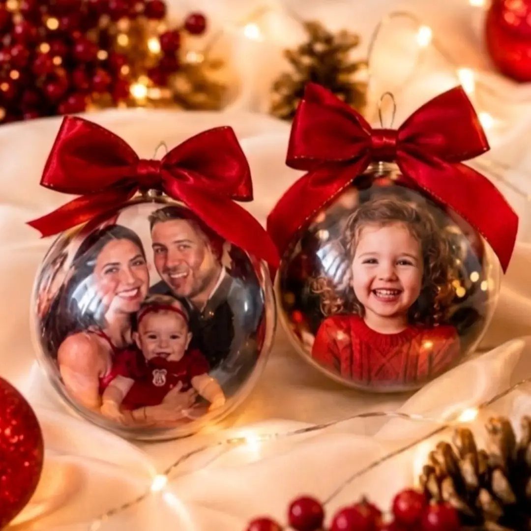 Clear glass Christmas ornaments with family photos inside and red satin bows.