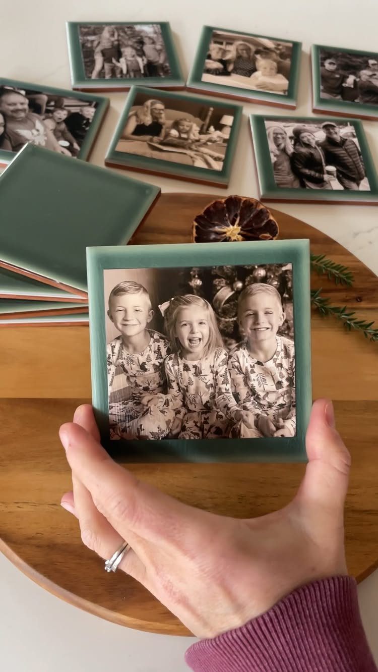 Hand holding a green square coaster with a black and white family photo.