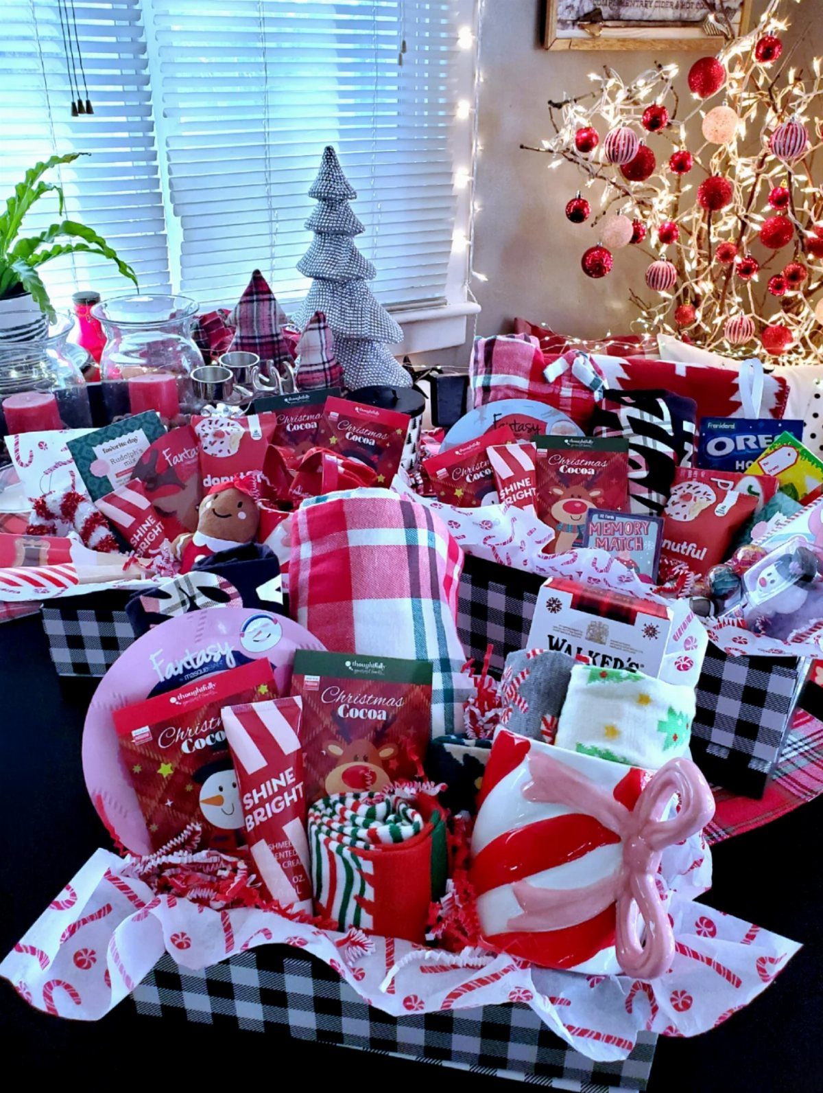Checkered gift baskets filled with red and white Christmas treats and cozy accessories.