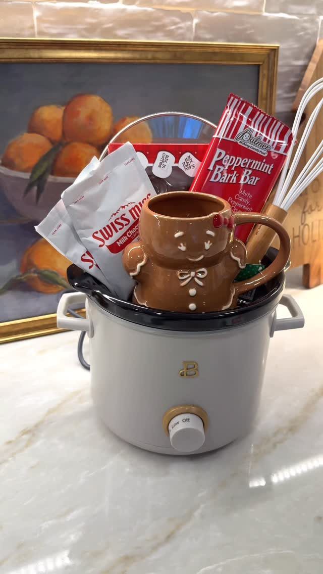 Hot cocoa kit in a white slow cooker with a gingerbread man mug.