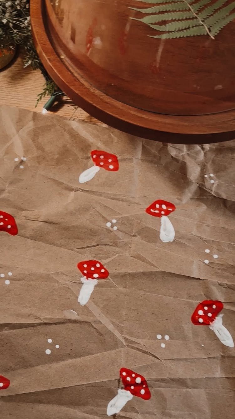 Brown kraft paper decorated with hand-painted red mushrooms and white dots.