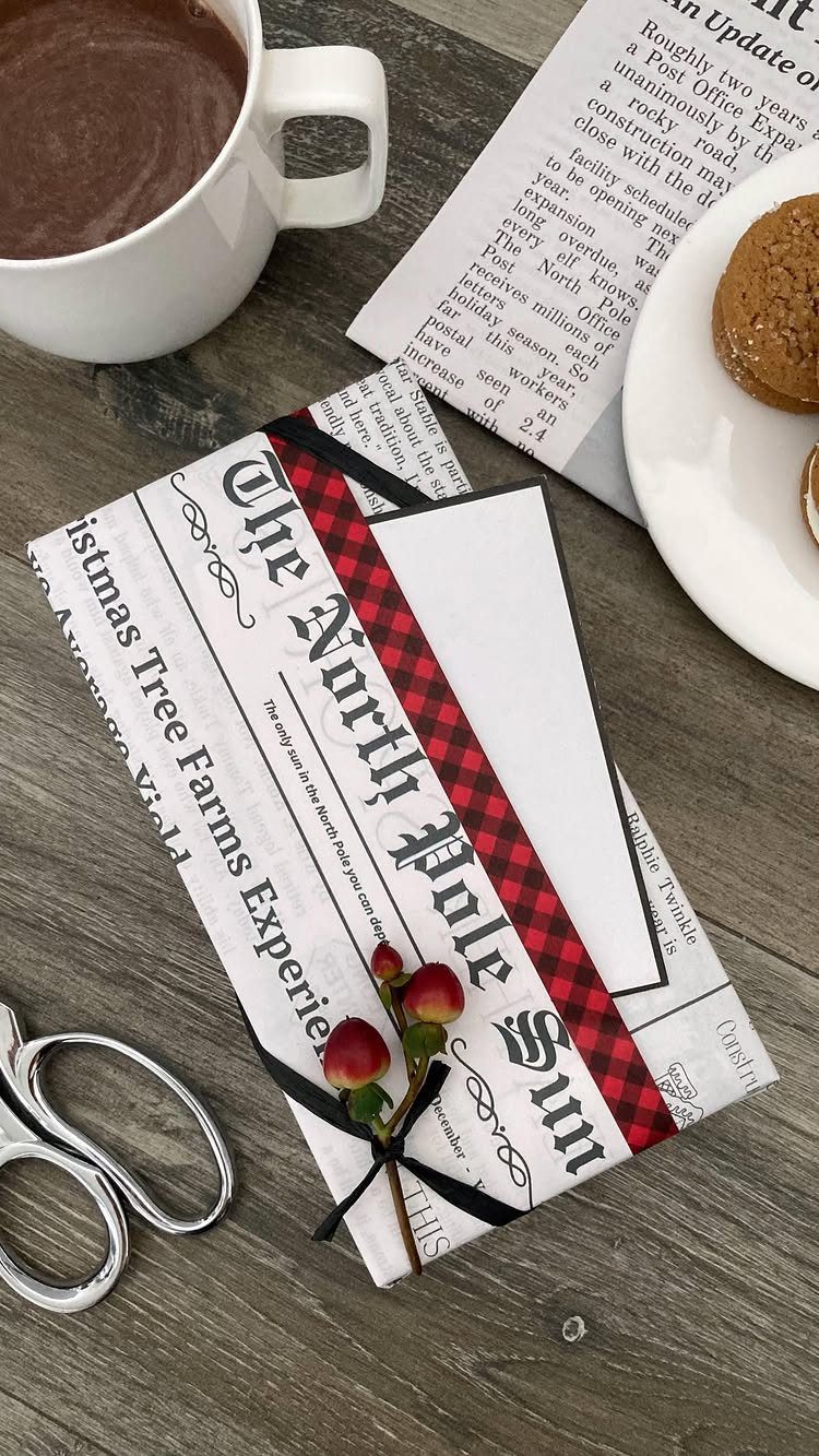 Gift wrapped in newspaper-style paper with a red checkered ribbon and berries.
