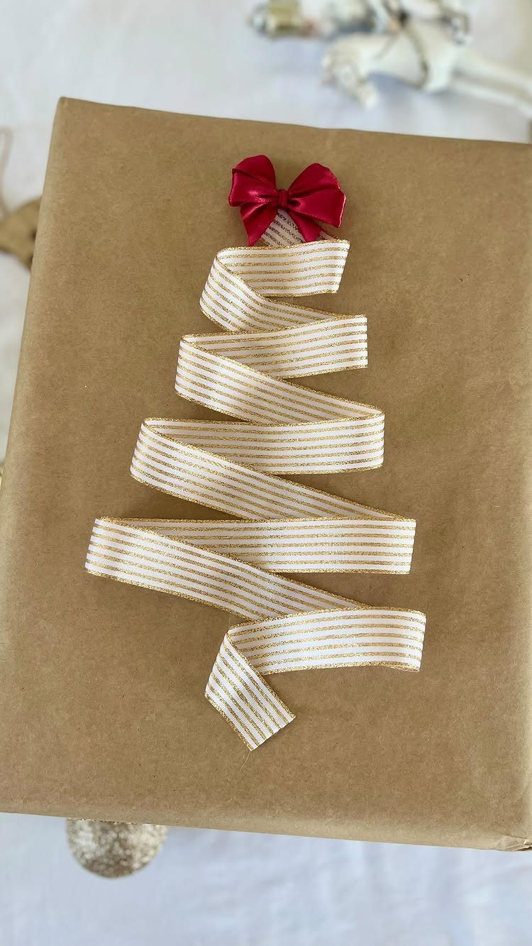 Brown wrapped gift box with a striped ribbon Christmas tree and red bow.