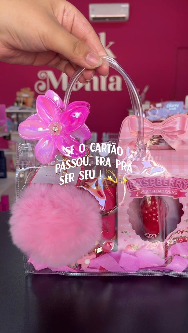 Clear plastic gift bag filled with pink fluffy accessories and beauty products.