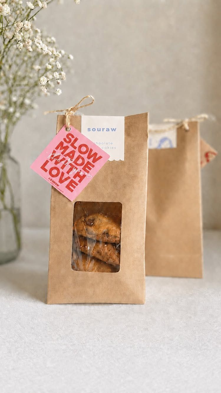Chocolate chip cookies in brown paper gift bags with a pink love tag.
