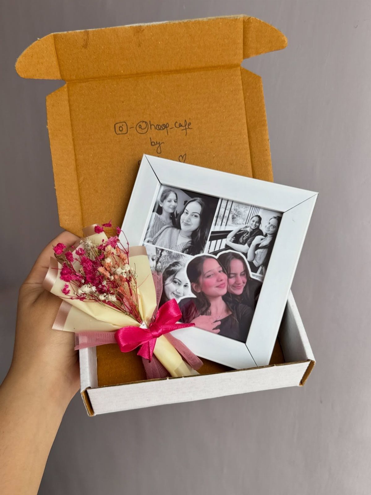 Small white photo frame and dried flower bouquet inside a white gift box.