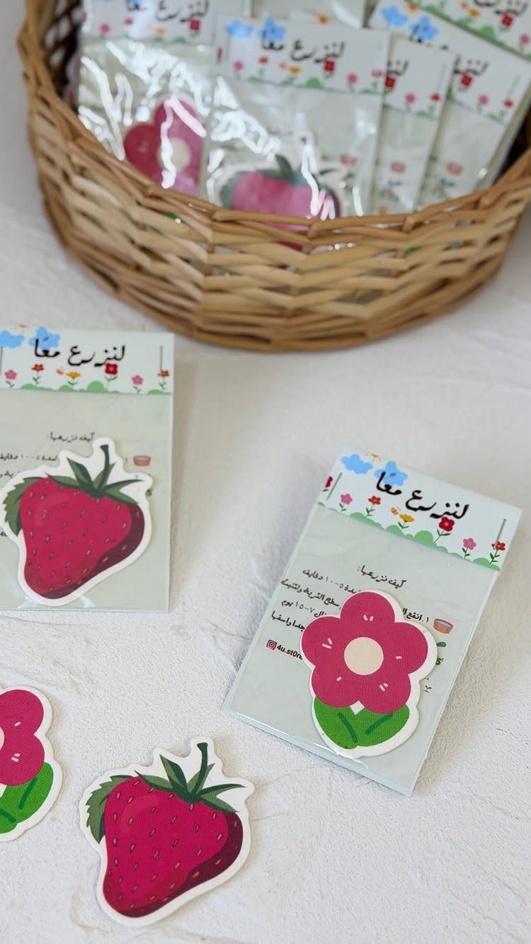 Seed packets with strawberry and flower illustrations in a wicker basket on white.