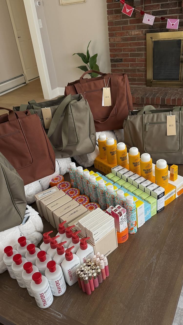 Tote bags and assorted toiletries arranged on a wooden table near a fireplace.