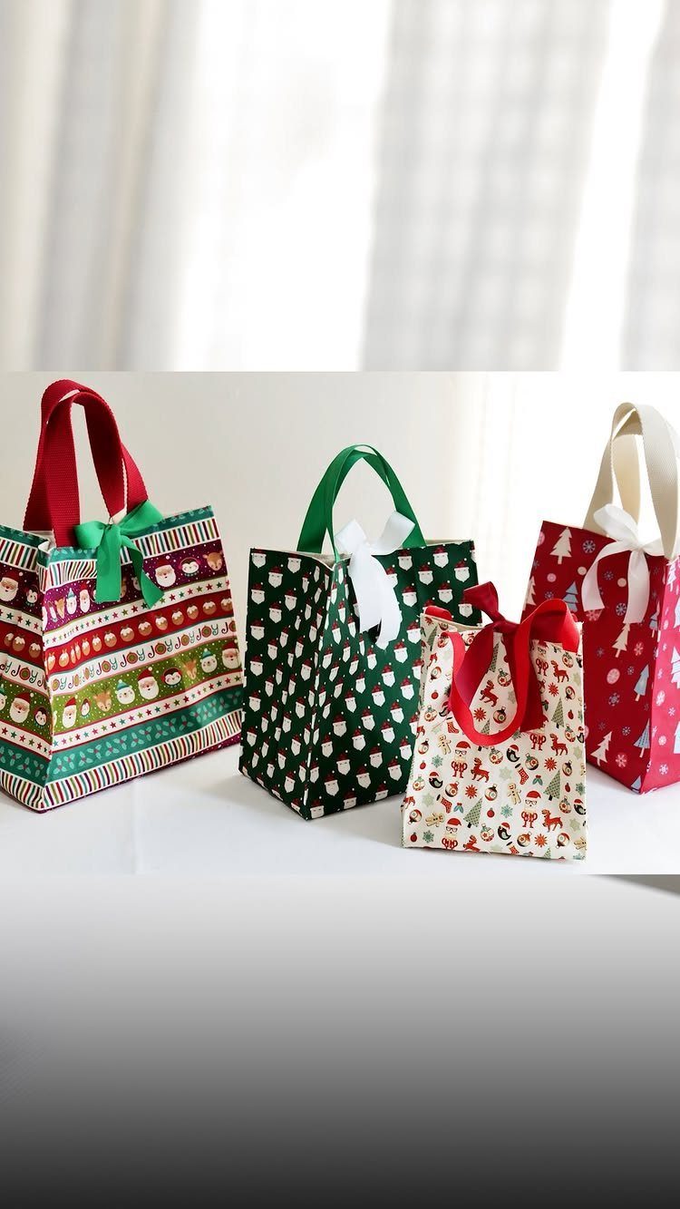 Christmas themed gift bags with festive patterns and ribbons on a white surface