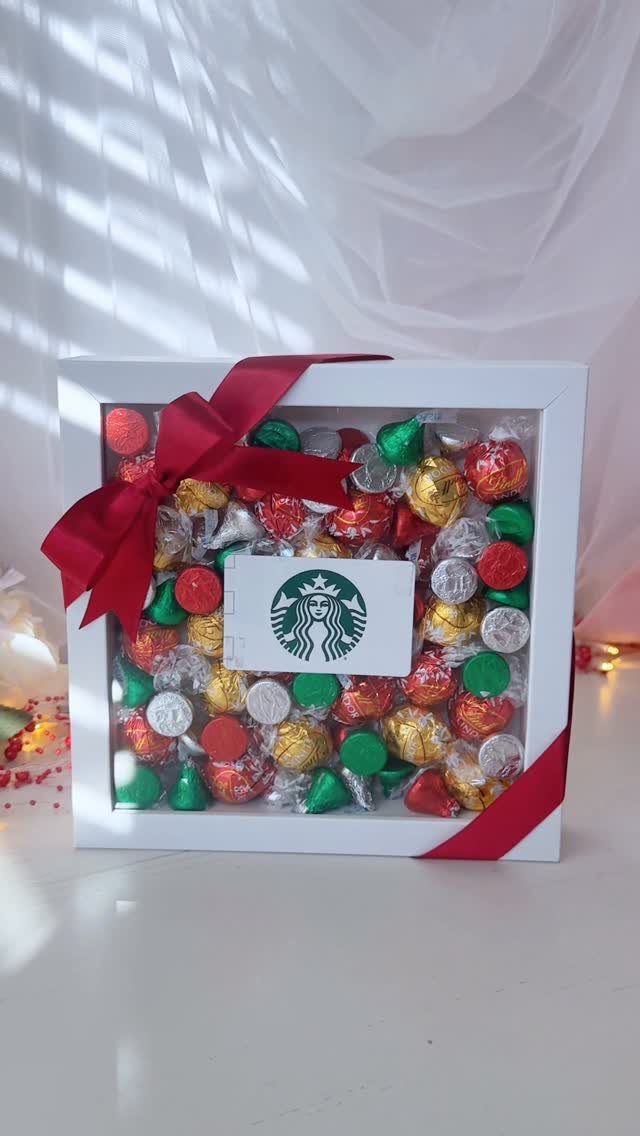 Starbucks gift card surrounded by colorful foil chocolates in a white ribboned box