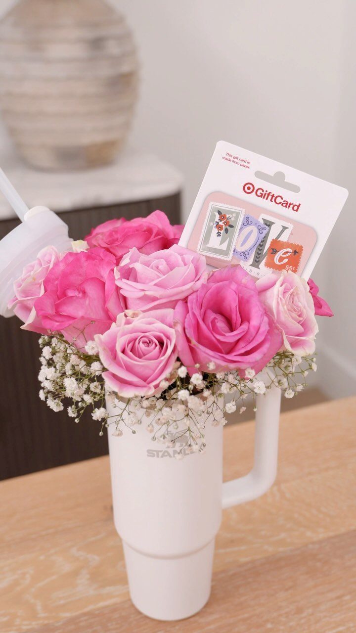 White travel mug filled with pink roses and a Target gift card.