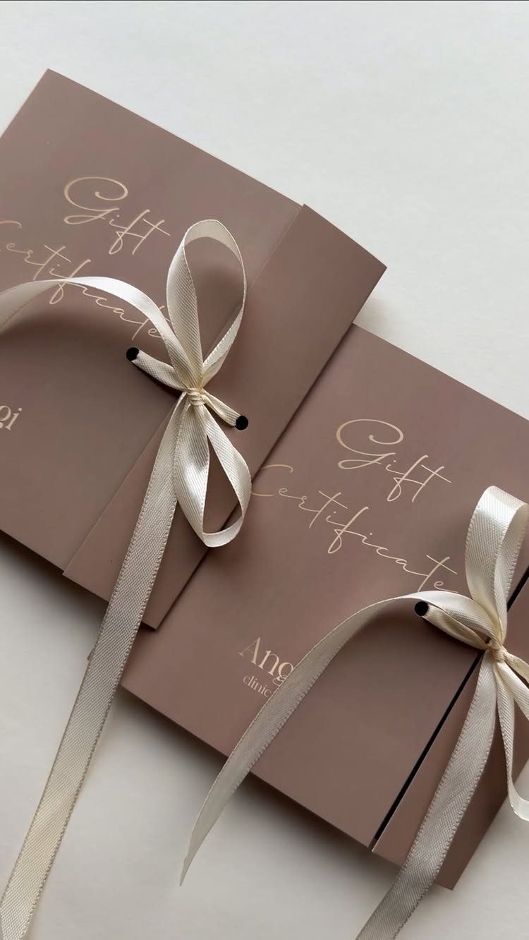Mauve gift certificate envelopes tied with cream satin ribbons on a white background