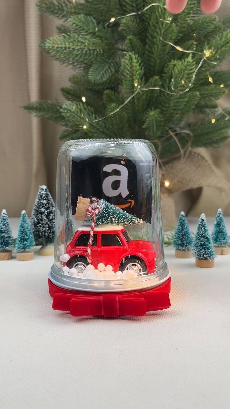 Amazon gift card inside a clear dome with a red toy car and snow