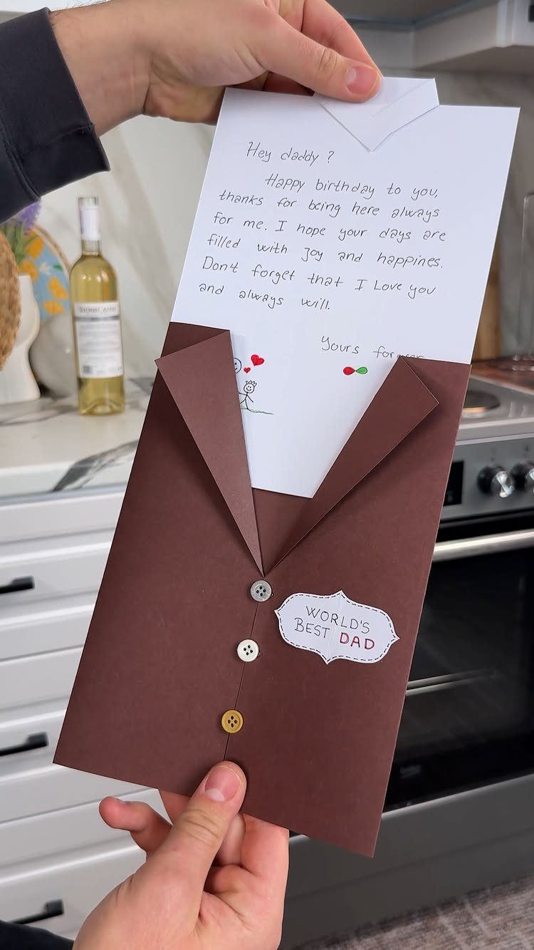 Brown suit jacket shaped card holding a handwritten birthday note for a father.