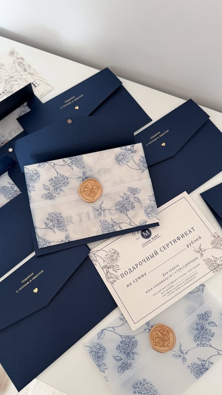 Gift certificates and envelopes with floral patterns and gold wax seals on white.