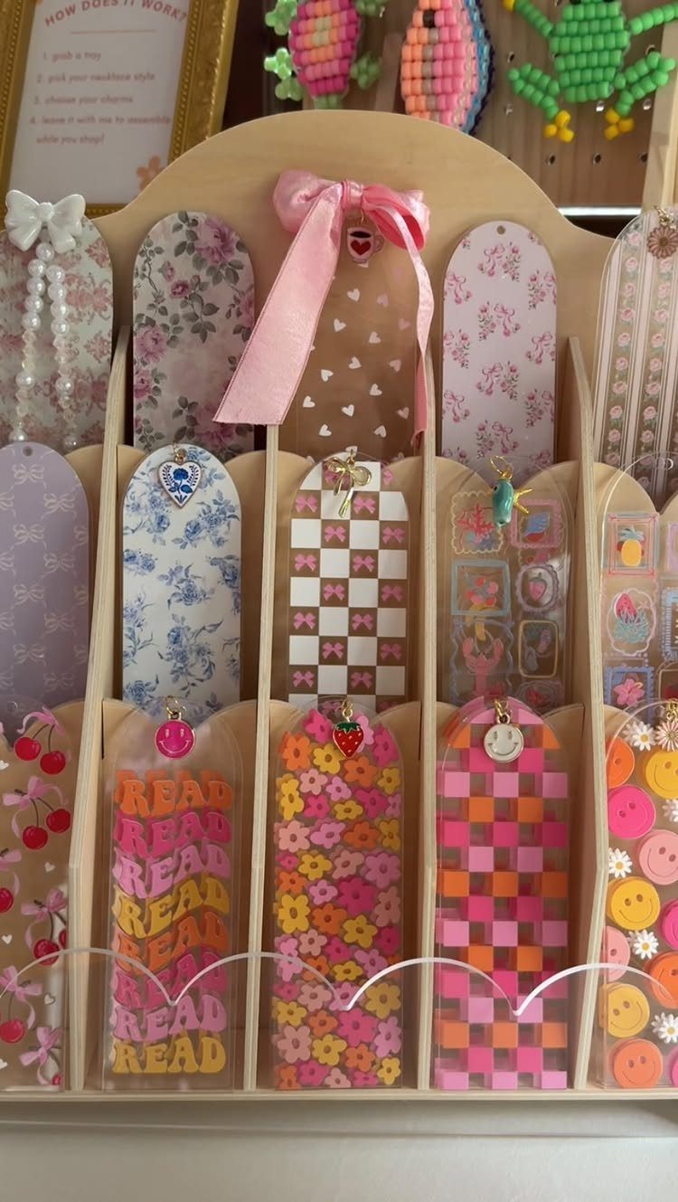 Colorful decorative bookmarks with floral and checkered patterns in a wooden display holder