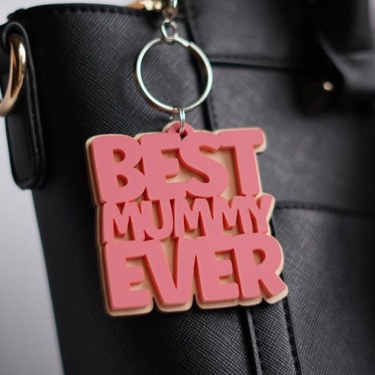 Pink BEST MUMMY EVER keychain hanging from a black leather handbag